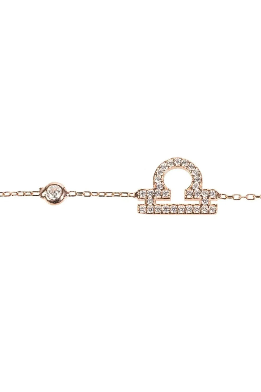 Rose gold tone bracelet close-up with CZ zodiac pendant and link chain