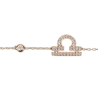 Rose gold tone bracelet close-up with CZ zodiac pendant and link chain