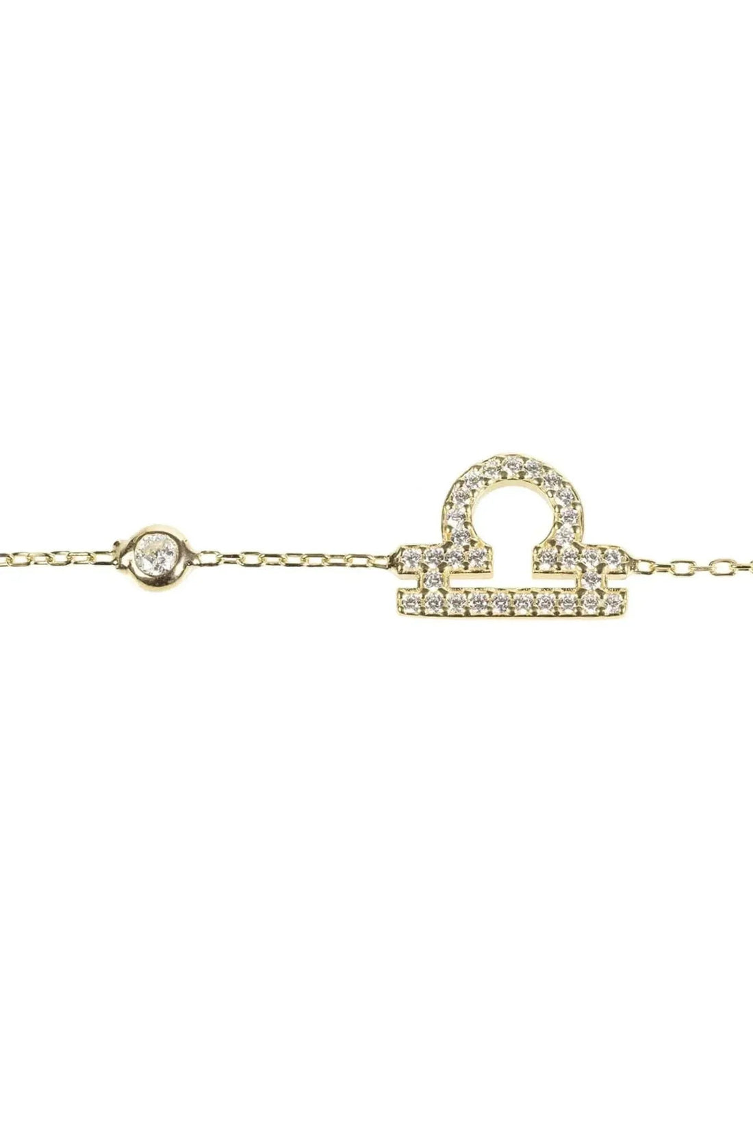 Gold tone bracelet close-up with CZ zodiac pendant and small round charm